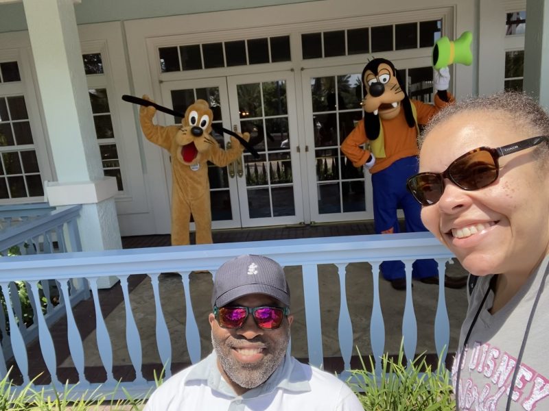 Couple poses with Goofy and Pluto