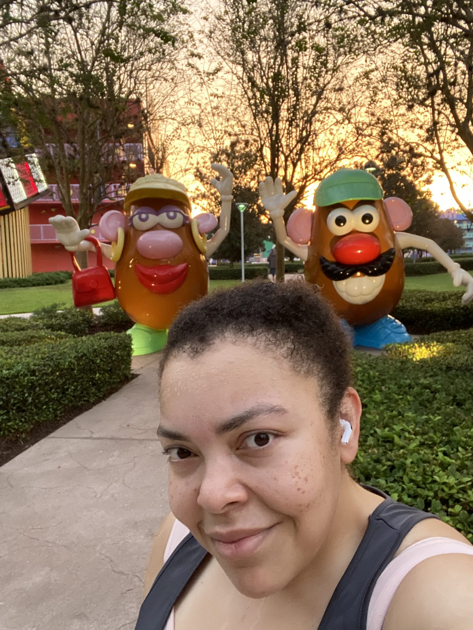 Woman poses in front of statues of Mr and Mrs Potato Head