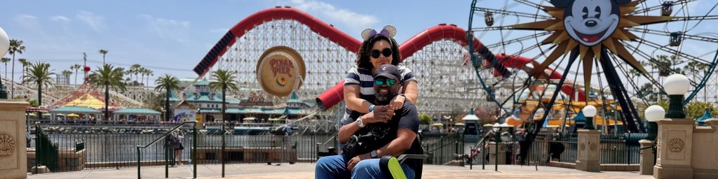 a photo of content creators, Brooke and Aadam, posing in front of the incredicoaster and Mickey's funwheel at Disney's California Adventure in Anaheim.